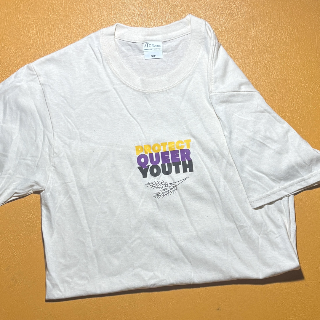 Natural Color Tshirt with graphic logo in yellow, purple, and black that says "Protect Queer Youth"